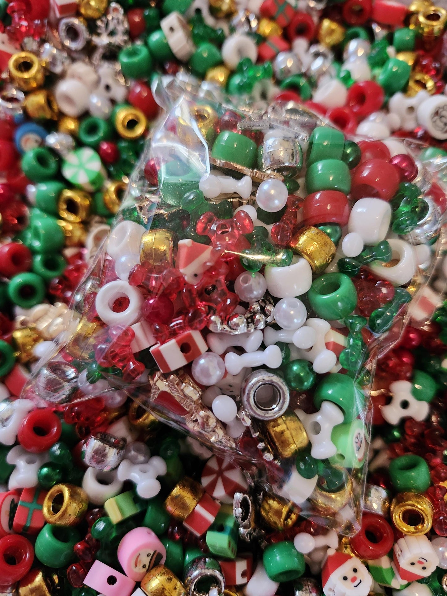 Christmas bead mix in a clear bag surrounded by colorful festive beads for holiday crafts