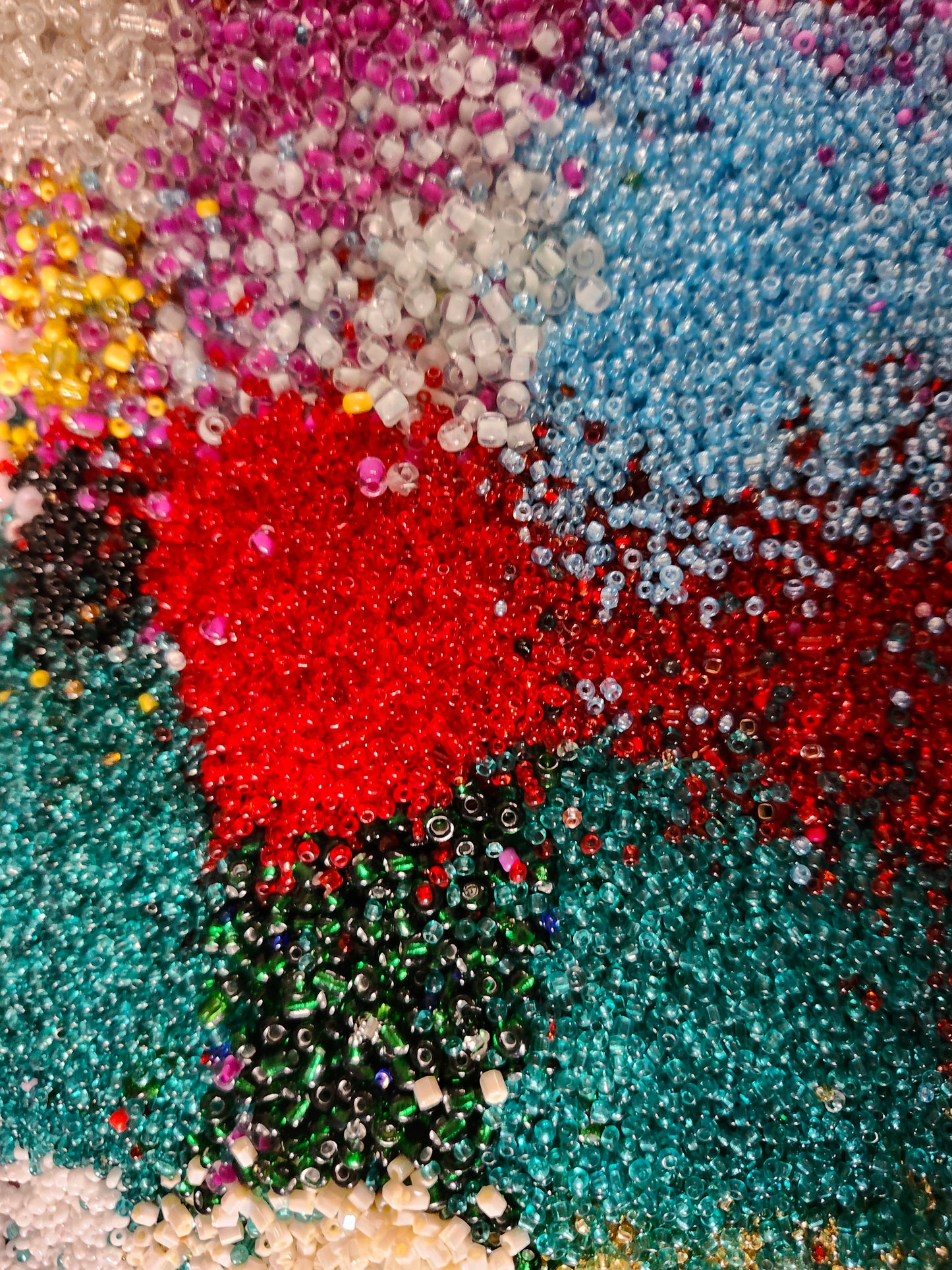 Vibrant assortment of colorful glass seed beads in various colors for crafting and jewelry making.