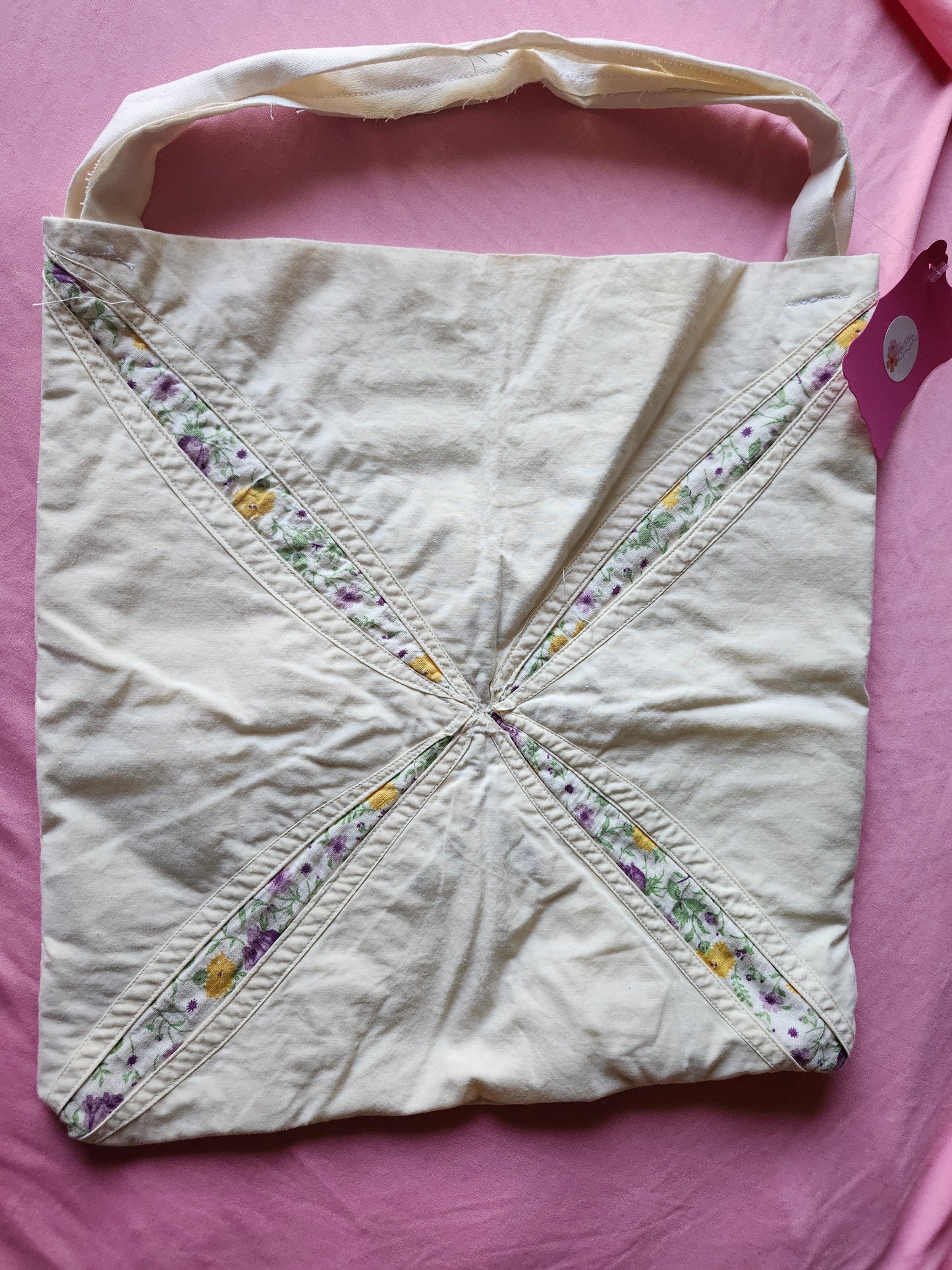 Handmade floral tote bag featuring a unique design with pastel flowers and sturdy handles