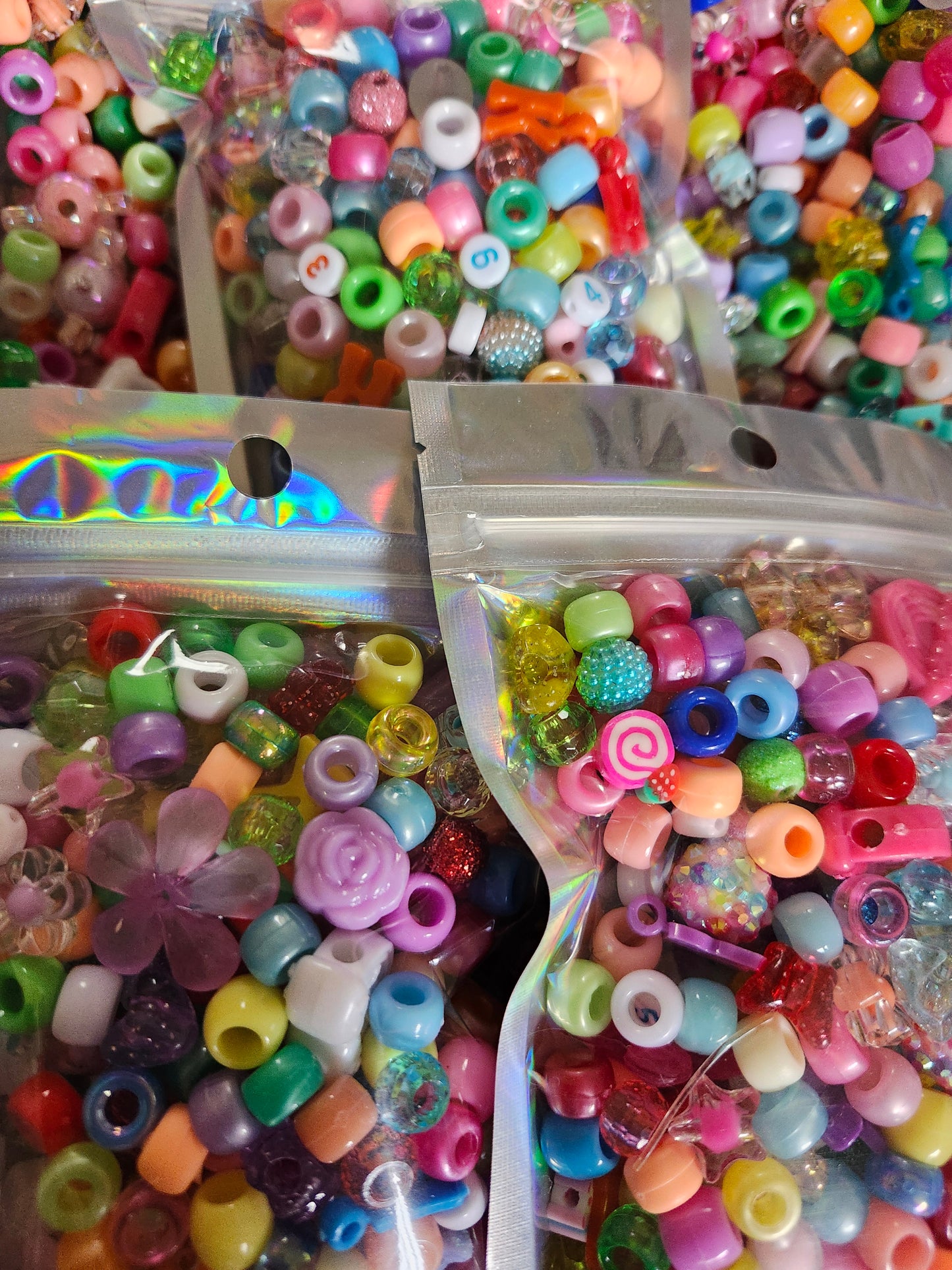 Assorted kawaii bead craft supplies in colorful bags for creative projects and fun jewelry making