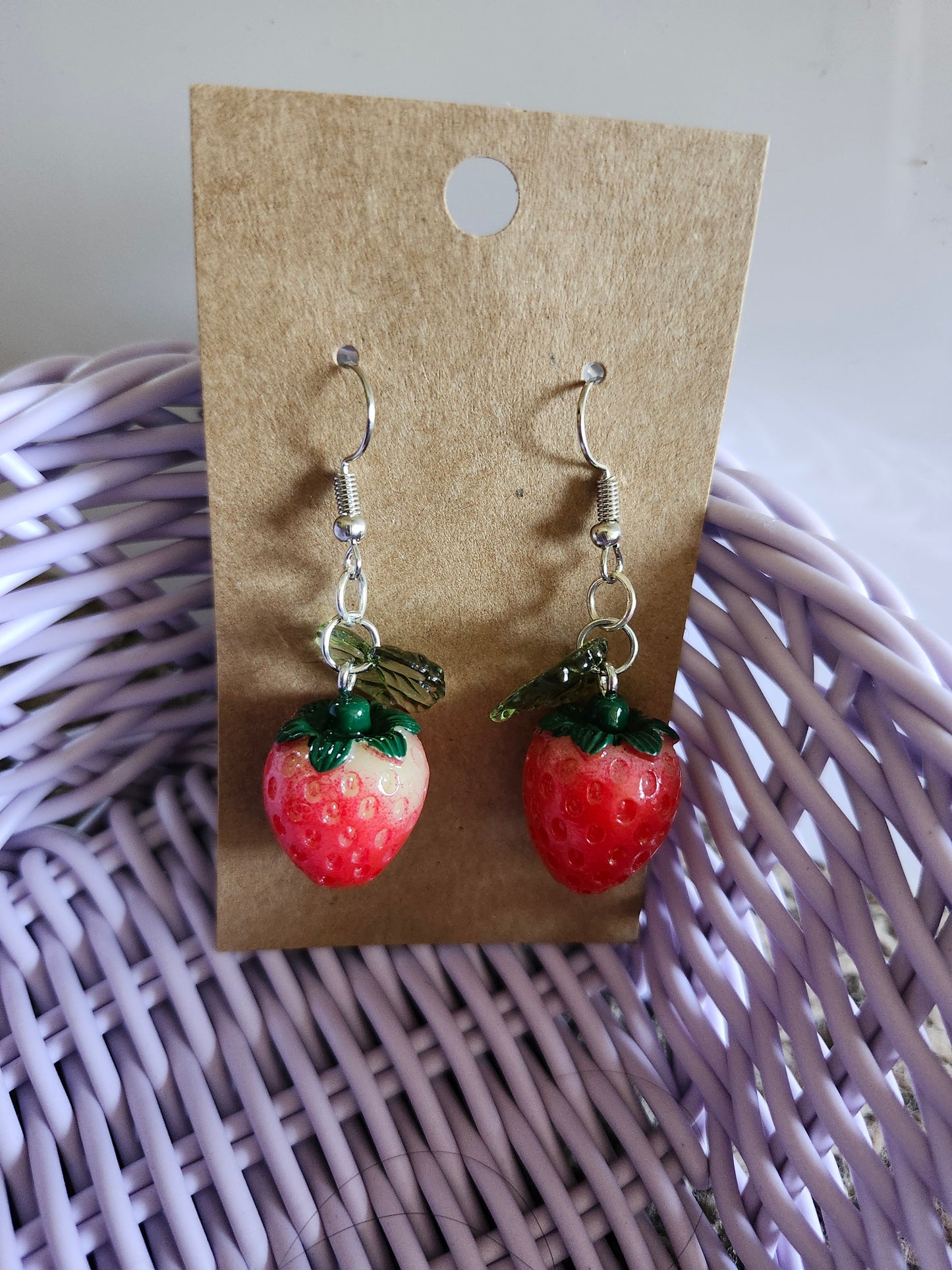 Kawaii strawberry earrings featuring colorful strawberry charms with green leaves on silver hooks