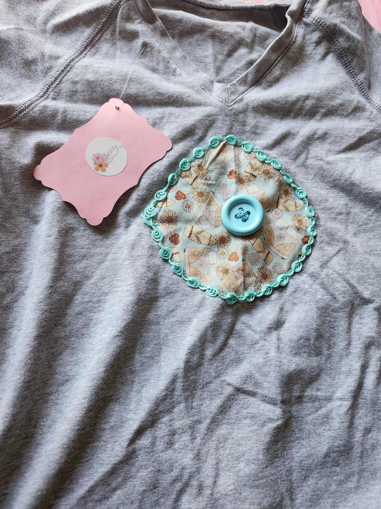 Gray Volkswagen upcycled tee featuring a unique decorative patch with a button