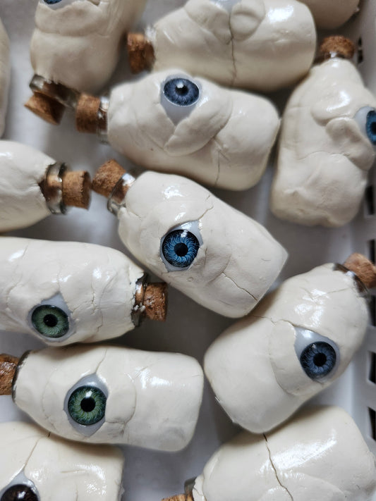 Handmade weirdcore decor featuring small clay bottles with unique glass eyes