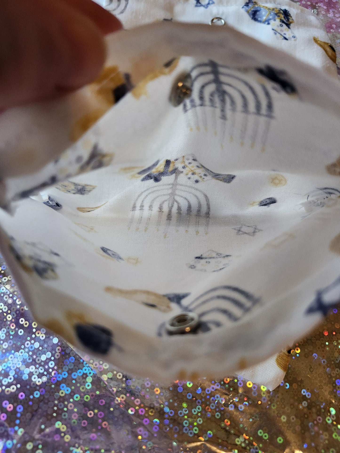 Inside view of a White Hanukkah gift pouch with festive patterns and gold accents