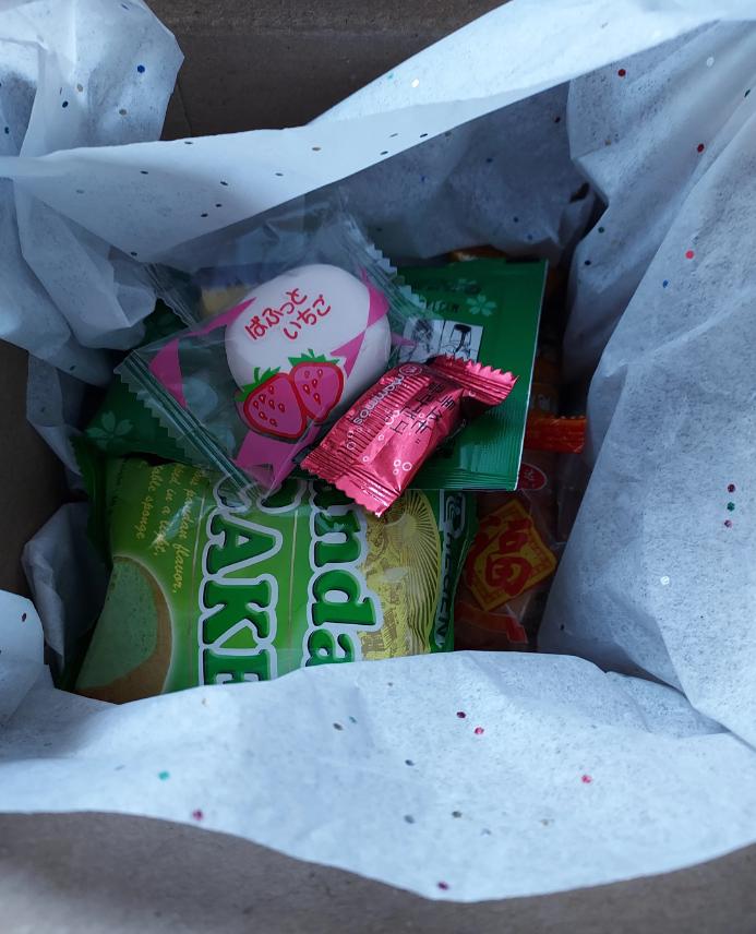 Asian snack box gift filled with various treats like green tea cookies and fruity candies
