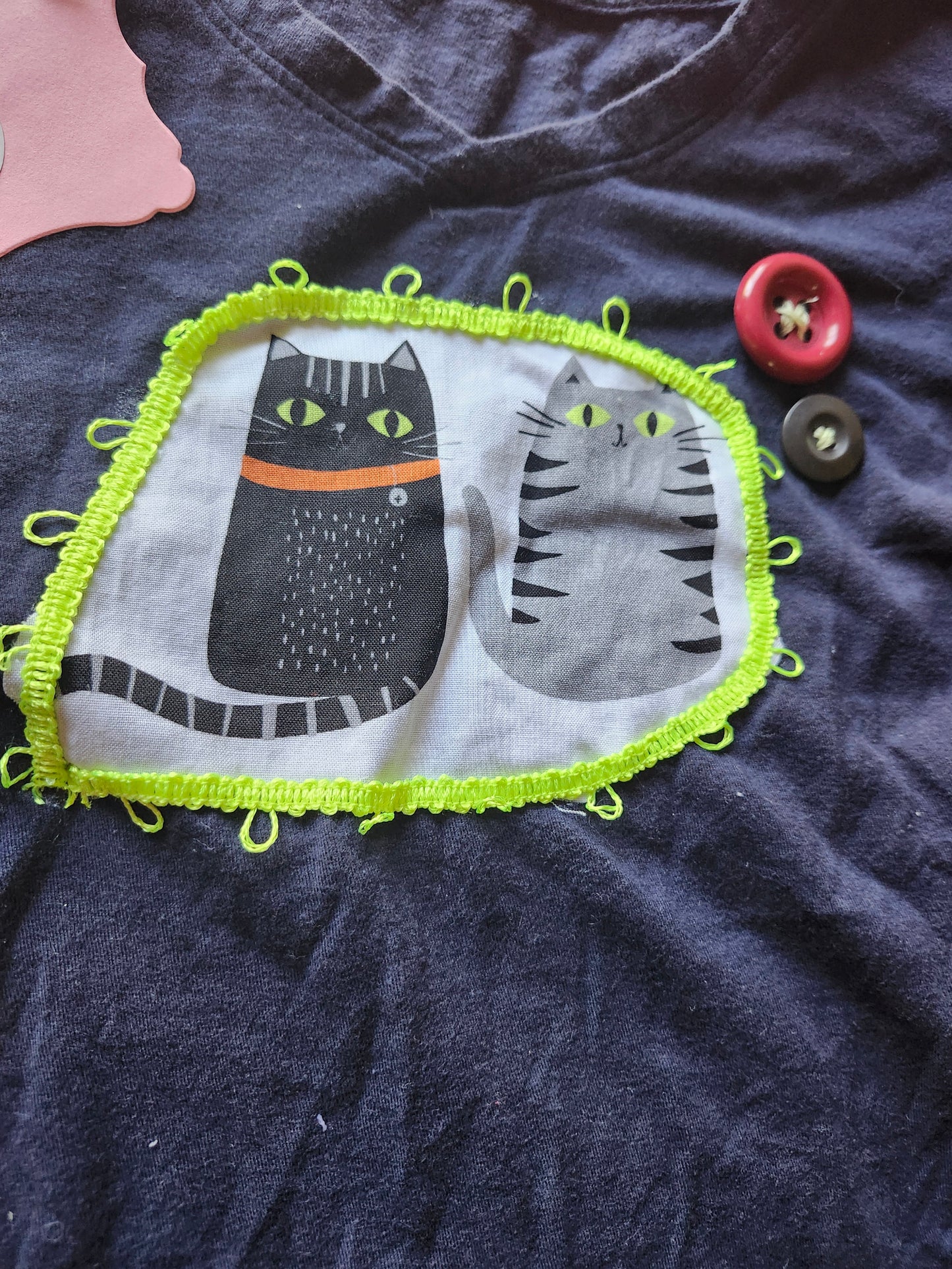Handmade cat apparel featuring playful cat illustrations on a navy shirt with colorful trim