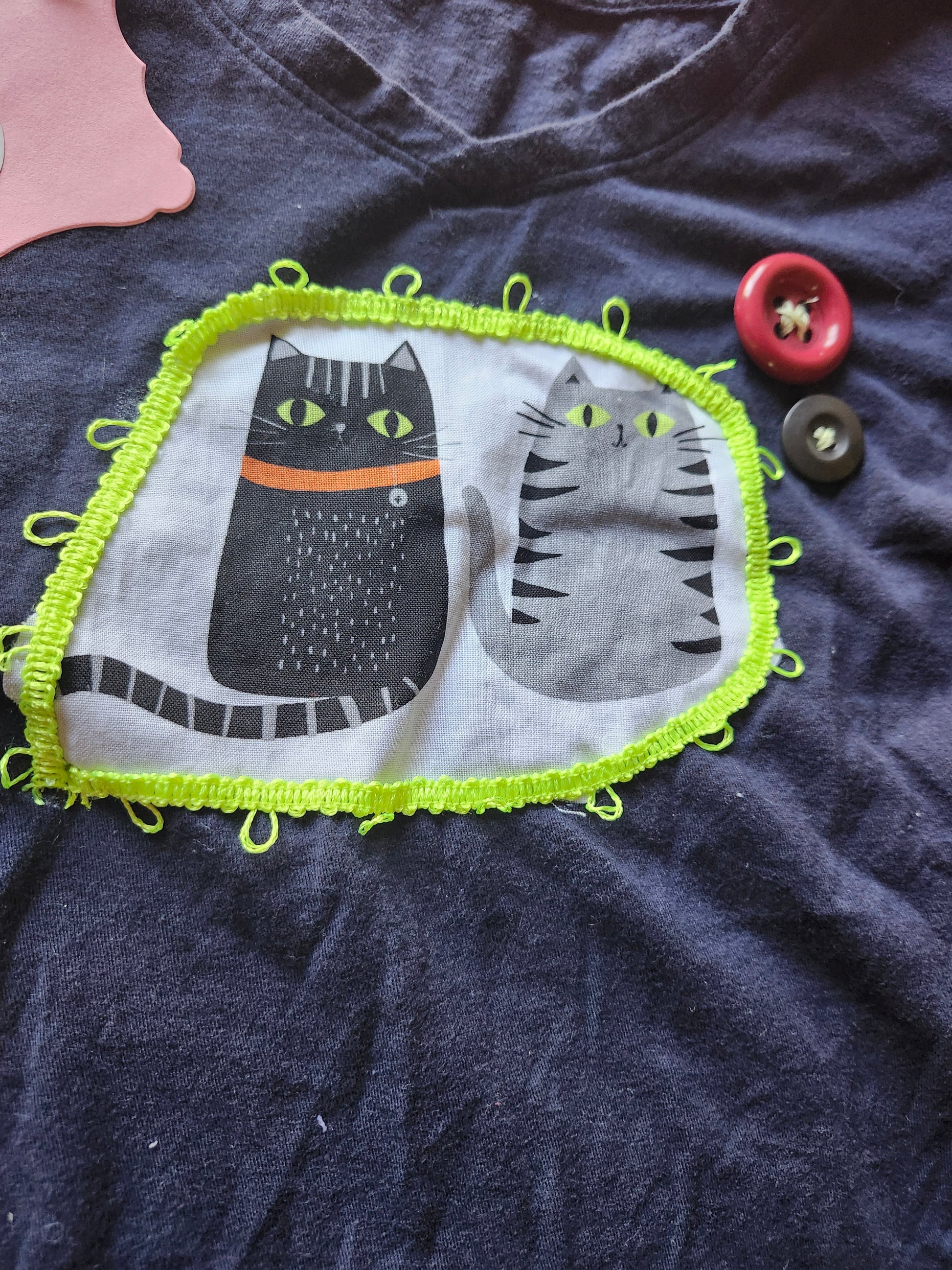 Handmade cat apparel featuring playful cat illustrations on a navy shirt with colorful trim