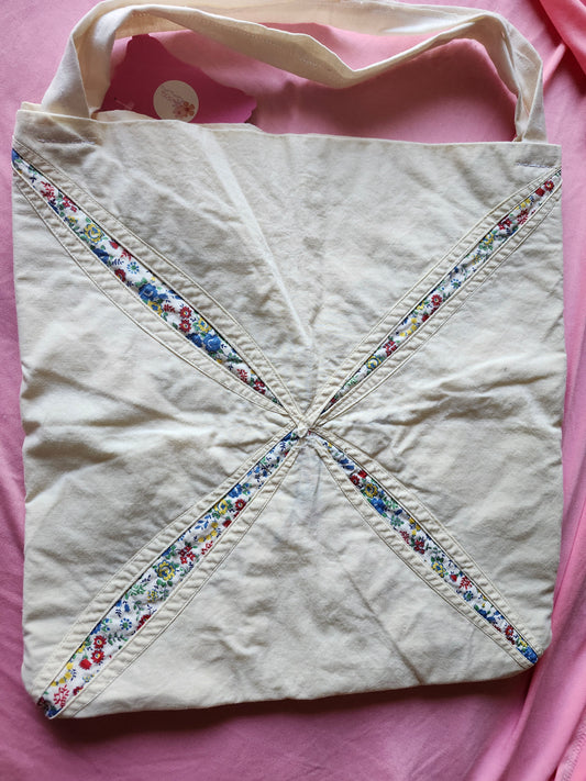 Handmade floral tote bag featuring colorful floral design on a soft cream background