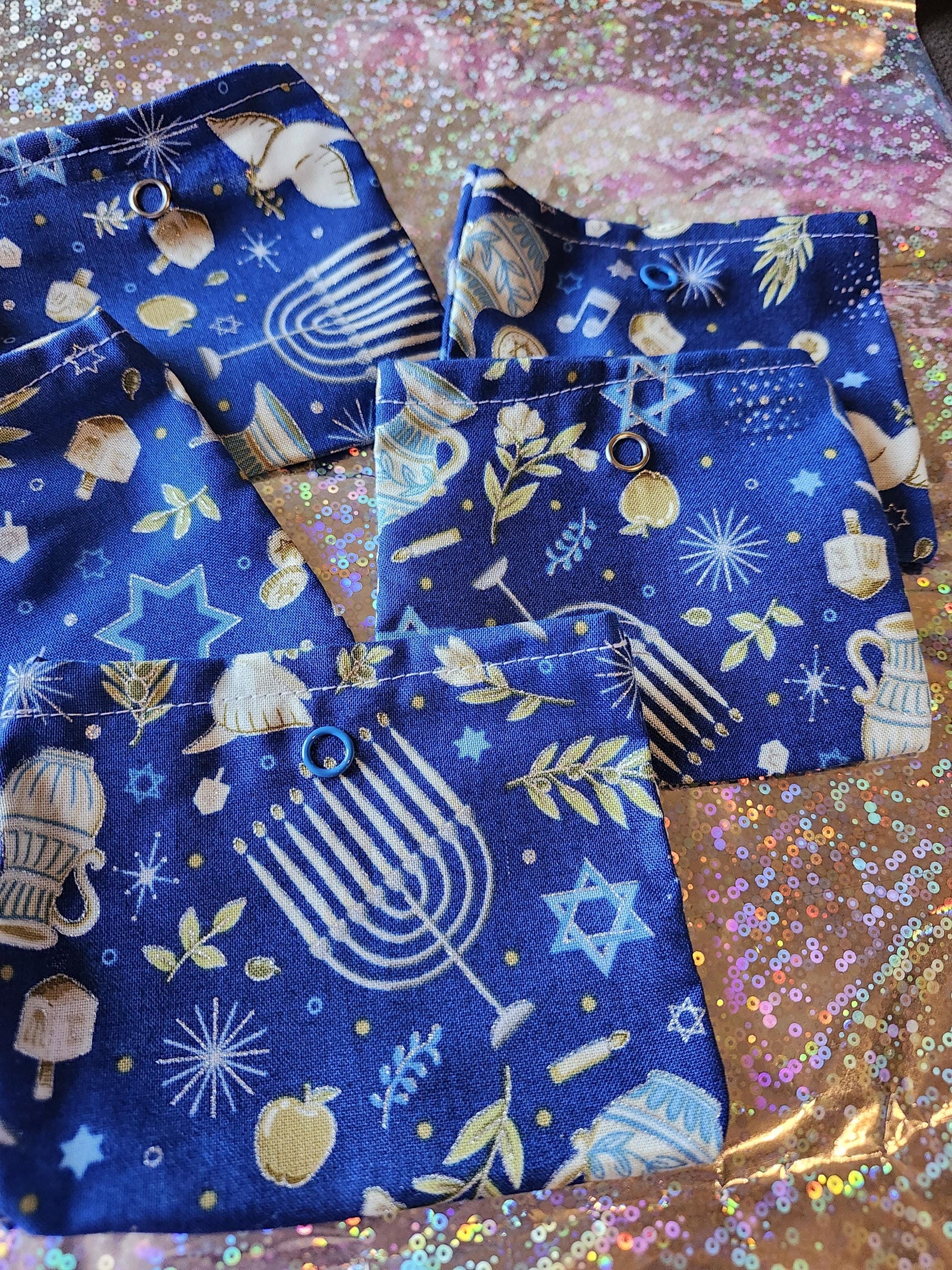 Four colorful Handmade Hanukkah gift pouches featuring menorahs and stars design