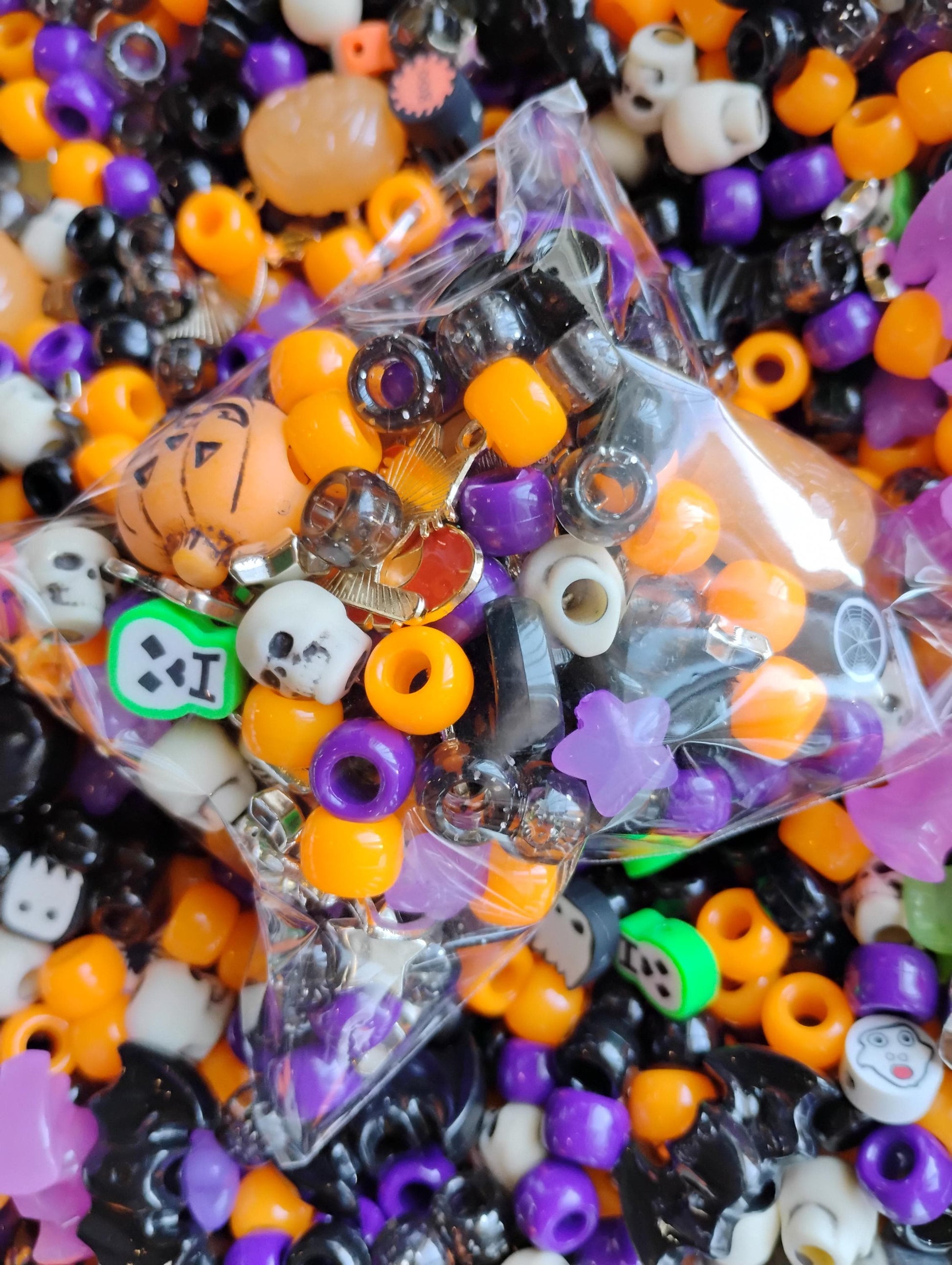 Colorful Kandi beads Halloween mix in a clear bag, featuring orange, black, purple, and decorative designs