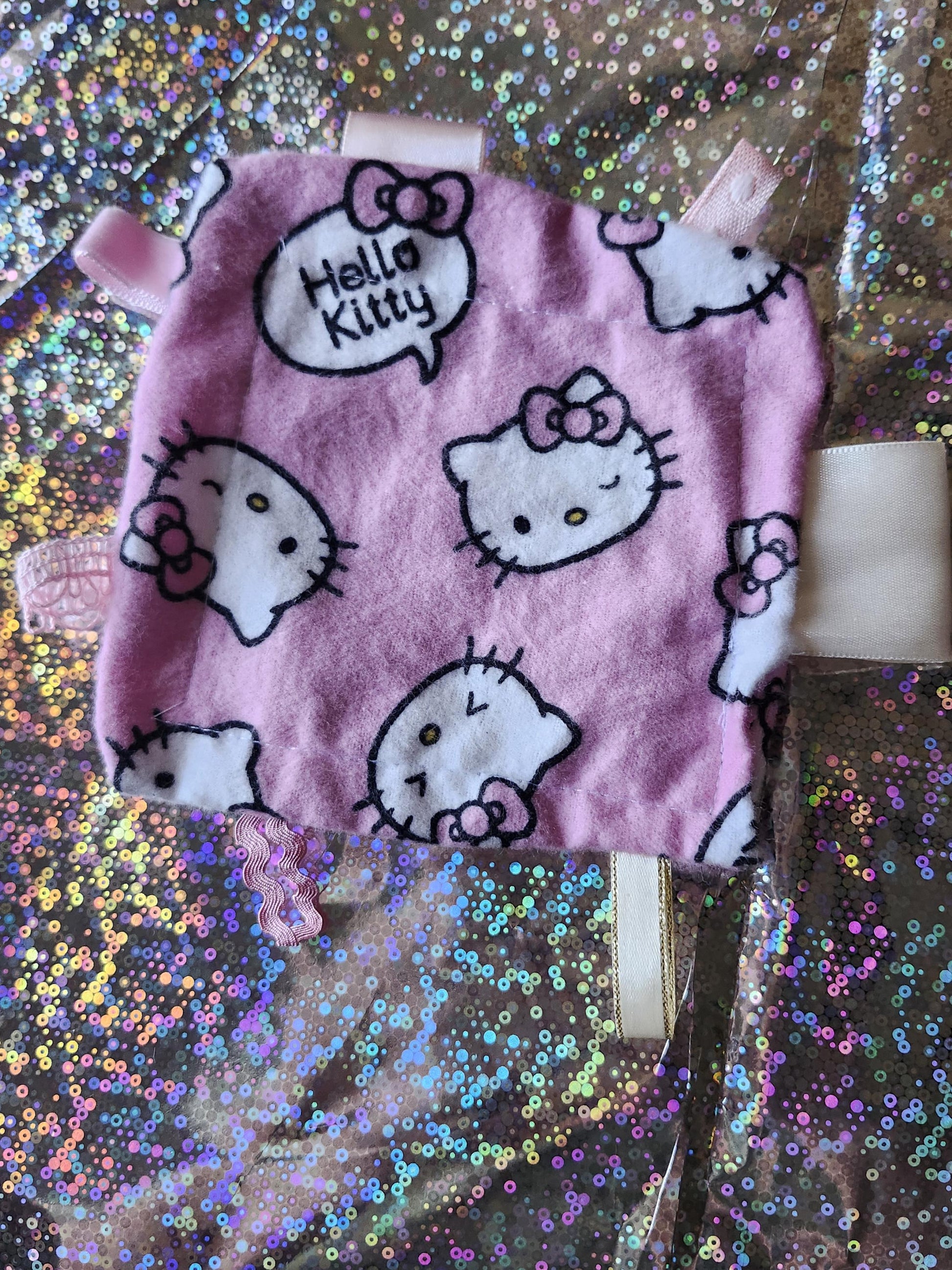 Kawaii Hello Kitty fidget toy in pink fabric featuring printed Hello Kitty faces and bows
