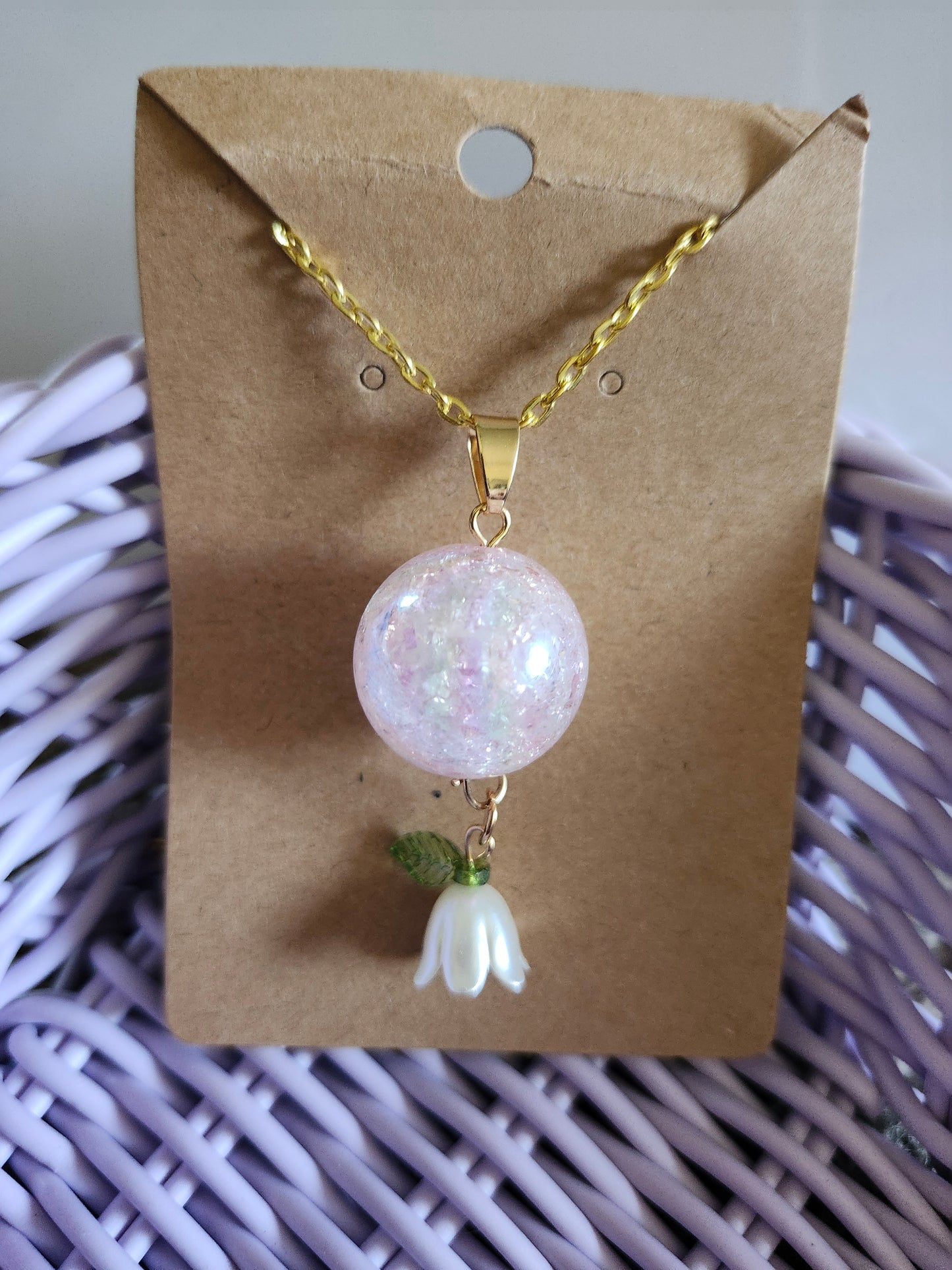 Kawaii pink lily necklace featuring a sparkling orb pendant and a delicate flower charm