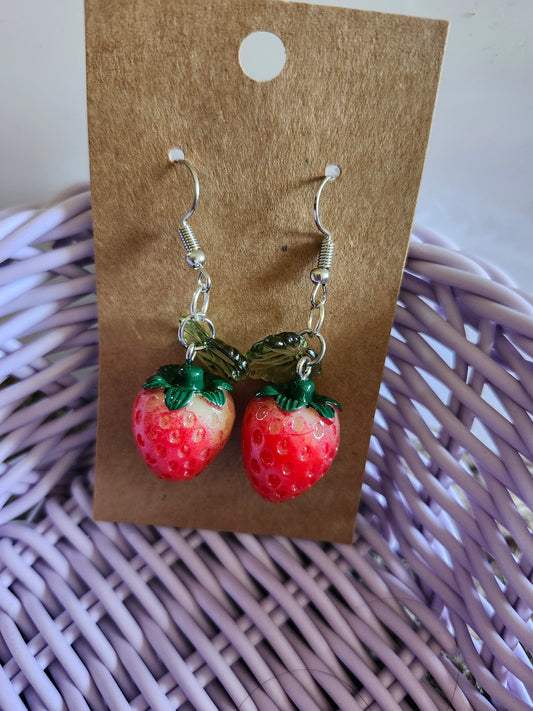 Kawaii strawberry earrings made of vibrant resin with green leaf details and silver hooks