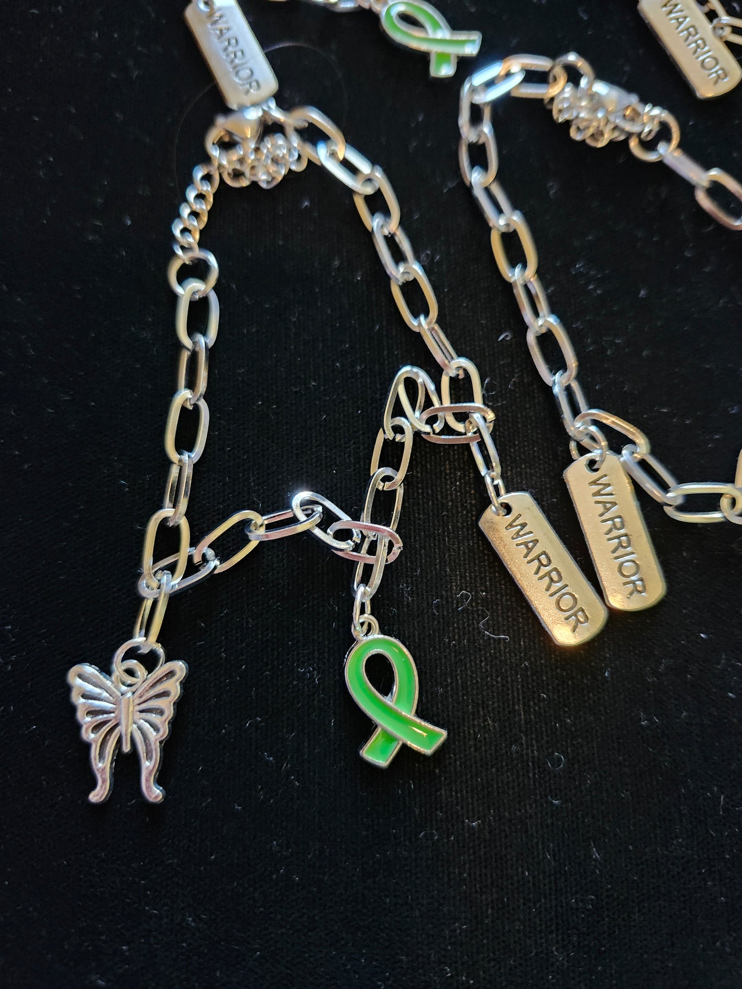 Mental health charm bracelet featuring a butterfly and green ribbon charms for awareness and support