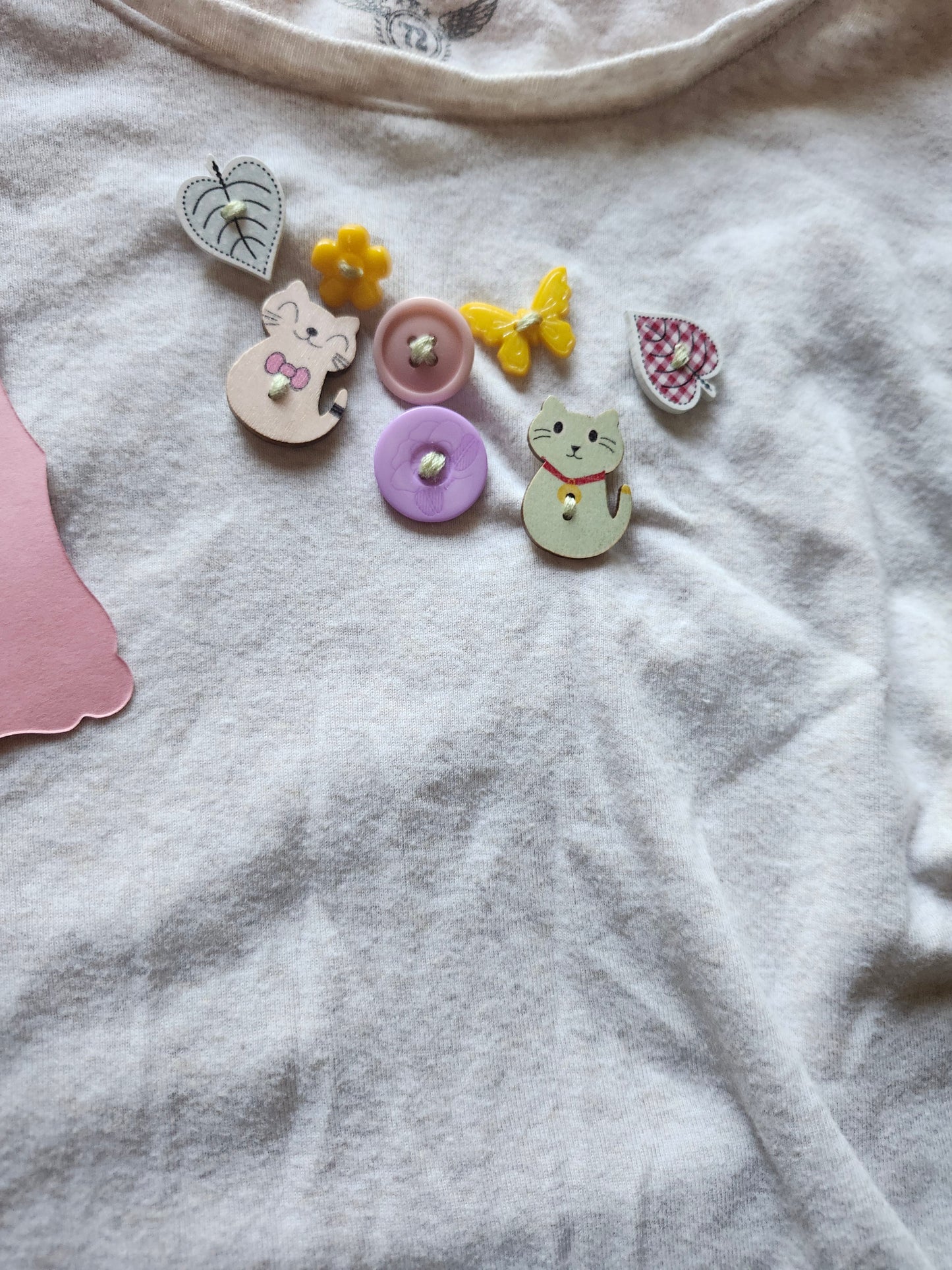Colorful quirky button designs featuring animals and flowers on a white fabric background