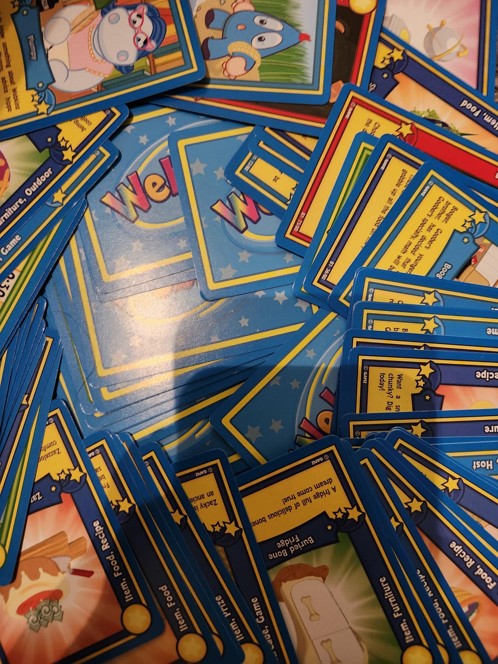 Collection of colorful Webkinz trading cards spread out on a table with vibrant designs